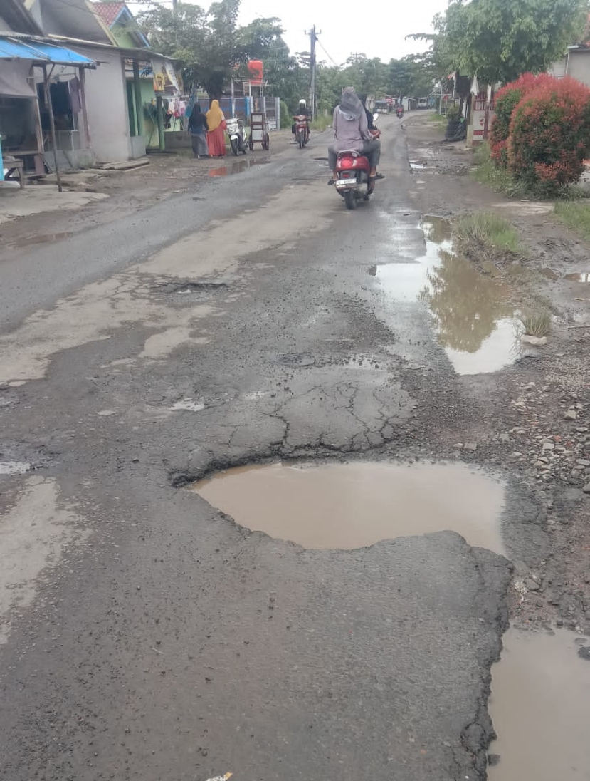 Caption : Kondisi Jalan Junti–Sampalan kian memprihatinkan. Permukaan jalan berlubang dan pecah, berpotensi membahayakan keselamatan pengguna jalan.