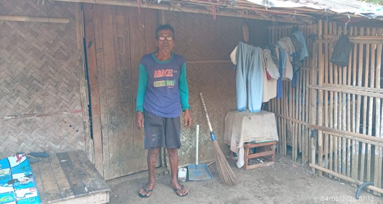 Caption : Abah Dasum berdiri di depan rumahnya yang nyaris roboh di Dusun Krajan RT 006/RW 002, Desa Pasirmukti, Kecamatan Telagasari, Kabupaten Karawang. Kondisi rumah berdinding bilik bambu dan atap rapuh tersebut sudah lama ditempati bersama keluarganya di tengah keterbatasan ekonomi