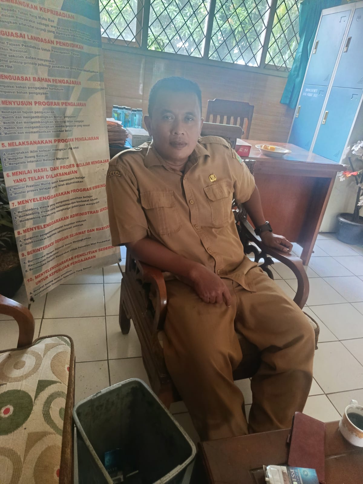 Caption : Kepala SMP Negeri 2 Rawamerta, Dedi Iskandar, saat ditemui di ruang kerjanya menjelaskan kegiatan pembenahan sarana dan prasarana sekolah yang dilakukan melalui alokasi Dana BOS untuk mendukung kenyamanan proses belajar mengajar.