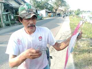 Caption : Adi menunjukkan benang gelasan layangan yang diduga sempat membelit tubuhnya saat melintas di Jalan Raya Kemiri, Kecamatan Jayakerta, Kabupaten Karawang, Senin (8/6/2026). Warga menilai benang layangan yang menjuntai di badan jalan tersebut membahayakan keselamatan pengguna jalan dan mendesak adanya penertiban dari pihak terkait. Foto: Patriotjabar.com/Mir Caption : Adi menunjukkan benang gelasan layangan yang diduga sempat membelit tubuhnya saat melintas di Jalan Raya Kemiri, Kecamatan Jayakerta, Kabupaten Karawang, Senin (8/6/2026). Warga menilai benang layangan yang menjuntai di badan jalan tersebut membahayakan keselamatan pengguna jalan dan mendesak adanya penertiban dari pihak terkait. Foto: Patriotjabar.com/Mir
