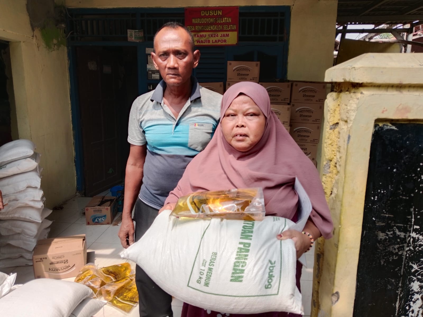 Caption : Warga Desa Rengasdengklok Selatan menerima bantuan beras dan minyak goreng dalam program BPNT-PKH Tahun 2026 yang disalurkan di Dusun Warudoyong Selatan, Kecamatan Rengasdengklok, Kabupaten Karawang. (Foto: Patriotjabar.com/Gugun)