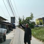 Caption : Kepala Dusun Warudoyong Utara, Muktar, menunjukkan kondisi kabel jaringan telekomunikasi yang menjuntai rendah dan semrawut di RT 33/RW 07, Desa Rengasdengklok Selatan, Kecamatan Rengasdengklok, Kabupaten Karawang. Warga meminta pihak terkait segera melakukan penataan dan perbaikan karena dinilai berpotensi membahayakan keselamatan pengguna jalan dan masyarakat sekitar. (Foto: Patriotjabar.com/Mir)