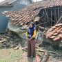 Caption : Ibu Sarwi berdiri di depan rumahnya yang roboh di Dusun Jatiboros RT 15/RW 05, Desa Kertajaya, Kecamatan Jayakerta, Kabupaten Karawang. Enam bulan pascakejadian akibat hujan deras disertai angin kencang, keluarga masih terpaksa menumpang di rumah kerabat sambil berharap adanya bantuan renovasi dari Pemerintah Kabupaten Karawang. (Foto: Gugun/Patriotjabar.com)