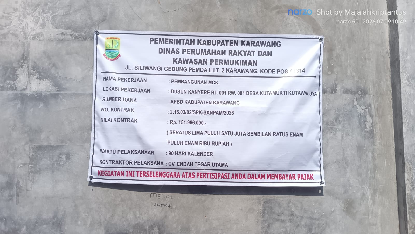 Caption : Papan informasi proyek pembangunan MCK yang bersumber dari APBD Kabupaten Karawang Tahun Anggaran 2026 di Dusun Kanyere RT 001/RW 001, Desa Kutamukti, Kecamatan Kutawaluya. Proyek senilai Rp151.966.000 yang dikerjakan oleh CV. Endah Tegar Utama tersebut menjadi sorotan menyusul adanya dugaan penggunaan pembesian cincin (ring balok) yang tidak sesuai spesifikasi teknis. Warga meminta DPRKP Kabupaten Karawang segera melakukan pemeriksaan dan verifikasi di lapangan guna memastikan pekerjaan dilaksanakan sesuai dokumen kontrak dan standar konstruksi yang berlaku. (Foto: Patriotjabar.com/Epeng).