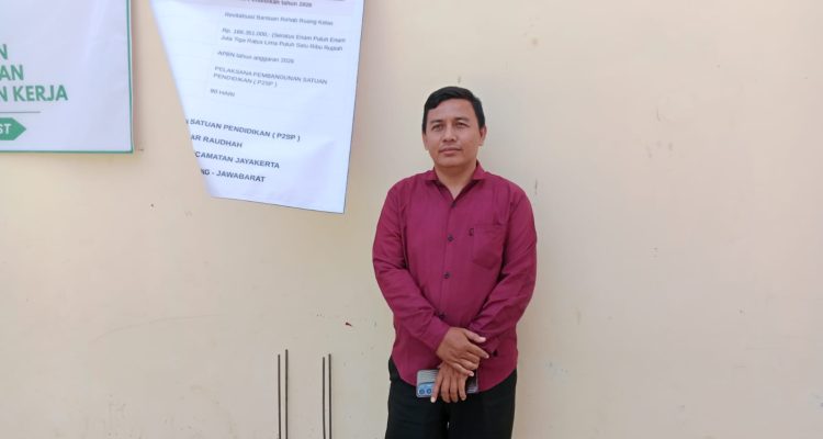 Caption : Kepala Sekolah PAUD Ar Raudhah, Rohmat, S.Pd., berfoto di depan papan informasi Program Revitalisasi Satuan Pendidikan Tahun 2026 di Desa Jayamakmur, Kecamatan Jayakerta, Kabupaten Karawang. Program bantuan pemerintah pusat tersebut dimanfaatkan untuk rehabilitasi ruang kelas guna meningkatkan Caption : Kepala Sekolah PAUD Ar Raudhah, Rohmat, S.Pd., berfoto di depan papan informasi Program Revitalisasi Satuan Pendidikan Tahun 2026 di Desa Jayamakmur, Kecamatan Jayakerta, Kabupaten Karawang. Program bantuan pemerintah pusat tersebut dimanfaatkan untuk rehabilitasi ruang kelas guna meningkatkan.