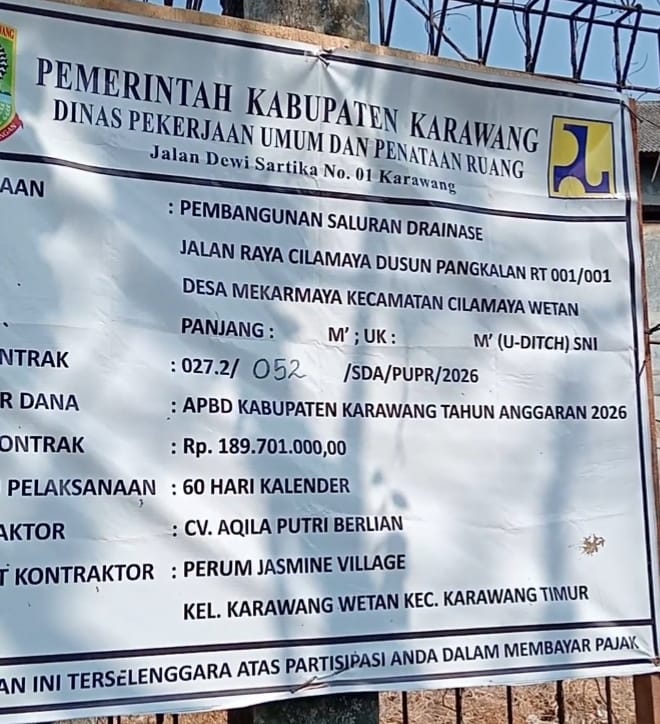 Foto: Papan informasi proyek pembangunan saluran drainase (U-Ditch) di Jalan Raya Cilamaya, Dusun Pangkalan RT 001/RW 001, Desa Mekarmaya, Kecamatan Cilamaya Wetan, Kabupaten Karawang. Proyek yang dibiayai APBD Kabupaten Karawang Tahun Anggaran 2026 senilai Rp189.701.000 tersebut menjadi sorotan warga karena diduga pemasangan U-Ditch dilakukan saat lokasi masih tergenang air dan tanpa hamparan pasir sebagai alas pemasangan. Dugaan tersebut diharapkan segera mendapat klarifikasi serta pemeriksaan dari pihak terkait. (Foto: Patriotjabar.com)