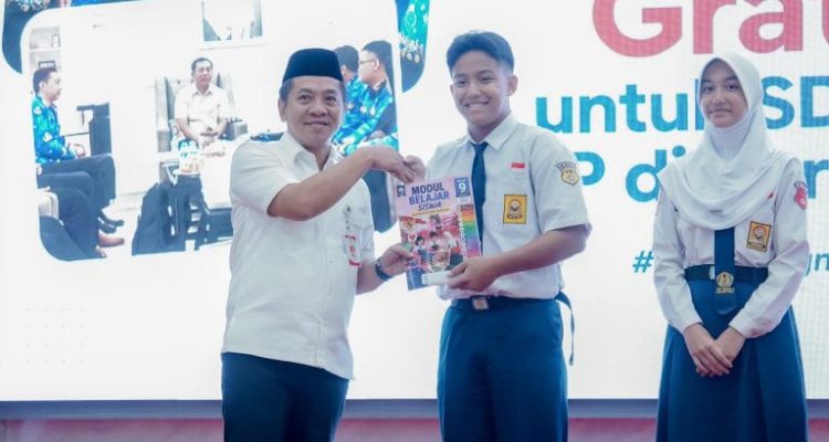 Caption : Bupati Karawang H. Aep Syaepuloh secara simbolis menyerahkan Modul Belajar Siswa Gratis kepada perwakilan siswa SMP saat peluncuran Program Modul Belajar Siswa Gratis bagi seluruh siswa SD dan SMP Negeri se-Kabupaten Karawang di Aula Husni Hamid, Kamis (23/7/2026), bertepatan dengan peringatan Hari Anak Nasional tingkat Kabupaten Karawang. Program ini bertujuan meringankan beban biaya pendidikan sekaligus meningkatkan kualitas pembelajaran. (Foto: Diskominfo Karawang) Caption : Bupati Karawang H. Aep Syaepuloh secara simbolis menyerahkan Modul Belajar Siswa Gratis kepada perwakilan siswa SMP saat peluncuran Program Modul Belajar Siswa Gratis bagi seluruh siswa SD dan SMP Negeri se-Kabupaten Karawang di Aula Husni Hamid, Kamis (23/7/2026), bertepatan dengan peringatan Hari Anak Nasional tingkat Kabupaten Karawang. Program ini bertujuan meringankan beban biaya pendidikan sekaligus meningkatkan kualitas pembelajaran. (Foto: Diskominfo Karawang)