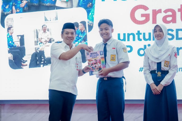 Caption : Bupati Karawang H. Aep Syaepuloh secara simbolis menyerahkan Modul Belajar Siswa Gratis kepada perwakilan siswa SMP saat peluncuran Program Modul Belajar Siswa Gratis bagi seluruh siswa SD dan SMP Negeri se-Kabupaten Karawang di Aula Husni Hamid, Kamis (23/7/2026), bertepatan dengan peringatan Hari Anak Nasional tingkat Kabupaten Karawang. Program ini bertujuan meringankan beban biaya pendidikan sekaligus meningkatkan kualitas pembelajaran. (Foto: Diskominfo Karawang) Caption : Bupati Karawang H. Aep Syaepuloh secara simbolis menyerahkan Modul Belajar Siswa Gratis kepada perwakilan siswa SMP saat peluncuran Program Modul Belajar Siswa Gratis bagi seluruh siswa SD dan SMP Negeri se-Kabupaten Karawang di Aula Husni Hamid, Kamis (23/7/2026), bertepatan dengan peringatan Hari Anak Nasional tingkat Kabupaten Karawang. Program ini bertujuan meringankan beban biaya pendidikan sekaligus meningkatkan kualitas pembelajaran. (Foto: Diskominfo Karawang)