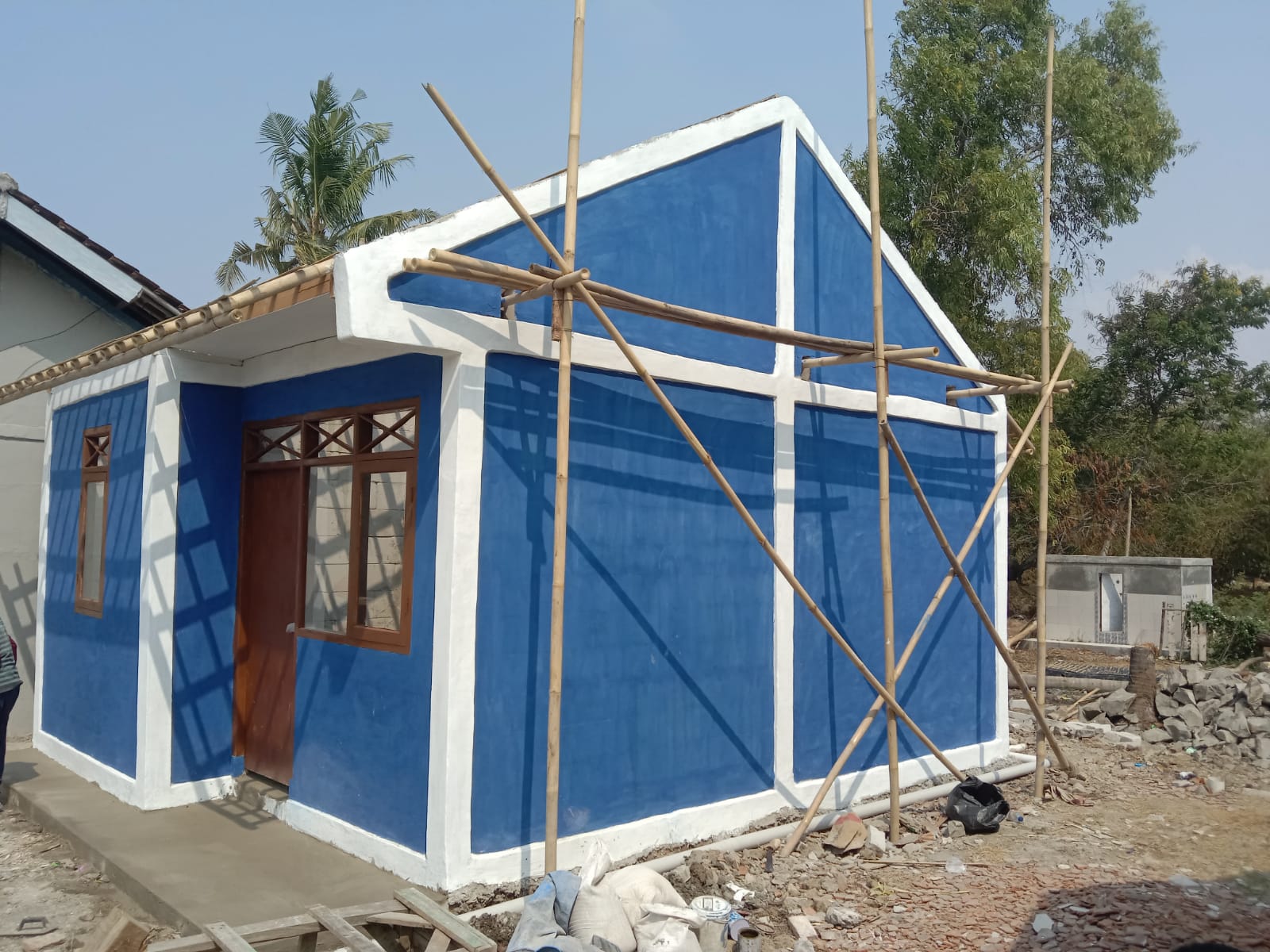 Caption : Kondisi rumah penerima manfaat Program Rumah Tidak Layak Huni (Rutilahu) Dinas PRKP Kabupaten Karawang di Dusun Bakan Buah, RT 01/RW 01, Kecamatan Rengasdengklok. Meski bangunan utama telah berdiri, pekerjaan diduga terhenti selama sekitar dua pekan karena material genteng belum dikirim, sehingga proses penyelesaian rumah belum dapat dilanjutkan. (Foto: Patriotjabar.com)