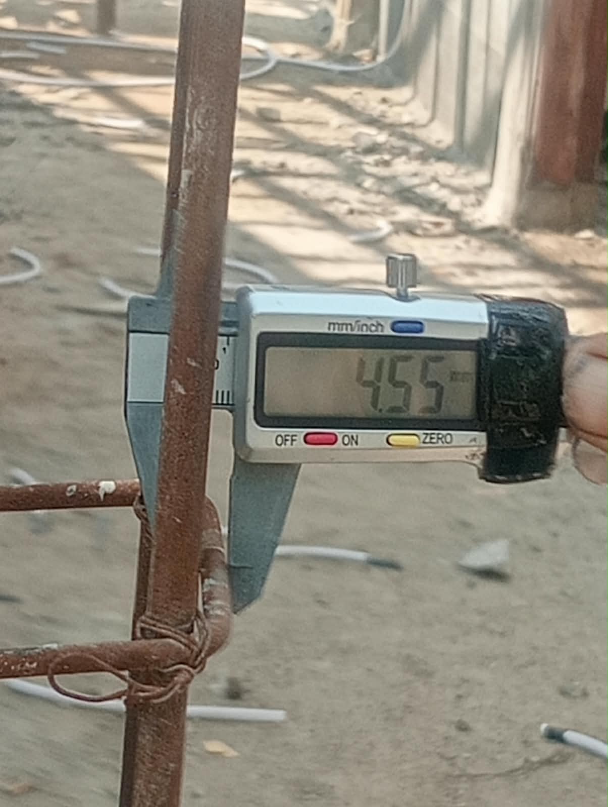 Caption : Alat ukur jangka sorong digital menunjukkan ukuran besi cincin sekitar 4,55 mm pada pekerjaan program Rumah Tidak Layak Huni (Rutilahu) di Dusun Cigobang, Desa Mekarpohaci, Kecamatan Cilebar, Karawang. Temuan tersebut menjadi bagian dari sorotan warga terkait dugaan ketidaksesuaian spesifikasi pekerjaan di lapangan.