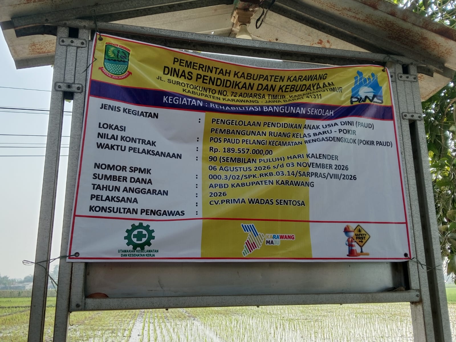 Caption : Papan informasi proyek rehabilitasi bangunan PAUD Pelangi di Kecamatan Rengasdengklok, Kabupaten Karawang, yang bersumber dari APBD Kabupaten Karawang Tahun Anggaran 2026 dengan nilai kontrak Rp189,557 juta. Proyek tersebut dilaksanakan CV Prima Wadas Sentosa dengan masa pelaksanaan 90 hari kalender, terhitung 6 Agustus hingga 3 November 2026.