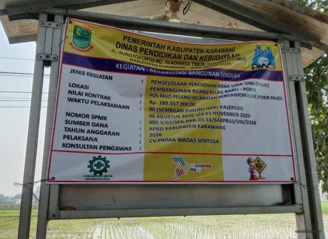 Caption : Papan informasi proyek pembangunan ruang kelas baru PAUD Pelangi di Kecamatan Rengasdengklok, Kabupaten Karawang. Proyek tersebut memiliki nilai kontrak Rp189,557 juta, bersumber dari APBD Kabupaten Karawang Tahun Anggaran 2026, dengan pelaksana CV Prima Wadas Sentosa dan waktu pelaksanaan 90 hari kalender.