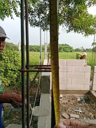 Caption: Pekerja tengah melakukan pekerjaan konstruksi pembangunan toilet SMPN 2 Jayakerta, Karawang. Terlihat pengukuran jarak pemasangan besi menggunakan meteran pada bagian struktur bangunan yang menjadi sorotan terkait dugaan ketidaksesuaian spesifikasi teknis. Caption: Pekerja tengah melakukan pekerjaan konstruksi pembangunan toilet SMPN 2 Jayakerta, Karawang. Terlihat pengukuran jarak pemasangan besi menggunakan meteran pada bagian struktur bangunan yang menjadi sorotan terkait dugaan ketidaksesuaian spesifikasi teknis.