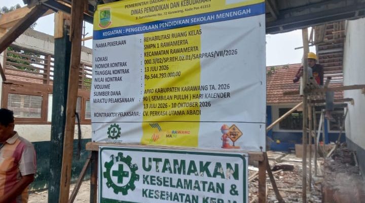 Caption : Papan informasi proyek rehabilitasi ruang kelas SMPN 1 Rawamerta, Kabupaten Karawang, yang mencantumkan nilai kontrak sebesar Rp544,799 juta dan pelaksana CV Perkasa Utama Abadi. Proyek tersebut menjadi sorotan terkait dugaan ketidaksesuaian spesifikasi material serta penerapan keselamatan dan kesehatan kerja (K3) di lapangan. Caption : Papan informasi proyek rehabilitasi ruang kelas SMPN 1 Rawamerta, Kabupaten Karawang, yang mencantumkan nilai kontrak sebesar Rp544,799 juta dan pelaksana CV Perkasa Utama Abadi. Proyek tersebut menjadi sorotan terkait dugaan ketidaksesuaian spesifikasi material serta penerapan keselamatan dan kesehatan kerja (K3) di lapangan.
