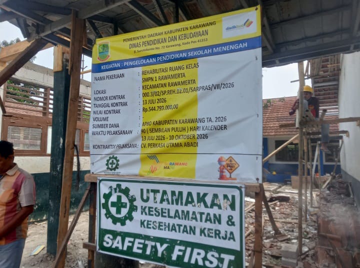 Caption : Papan informasi proyek rehabilitasi ruang kelas SMPN 1 Rawamerta, Kabupaten Karawang, yang mencantumkan nilai kontrak sebesar Rp544,799 juta dan pelaksana CV Perkasa Utama Abadi. Proyek tersebut menjadi sorotan terkait dugaan ketidaksesuaian spesifikasi material serta penerapan keselamatan dan kesehatan kerja (K3) di lapangan.
