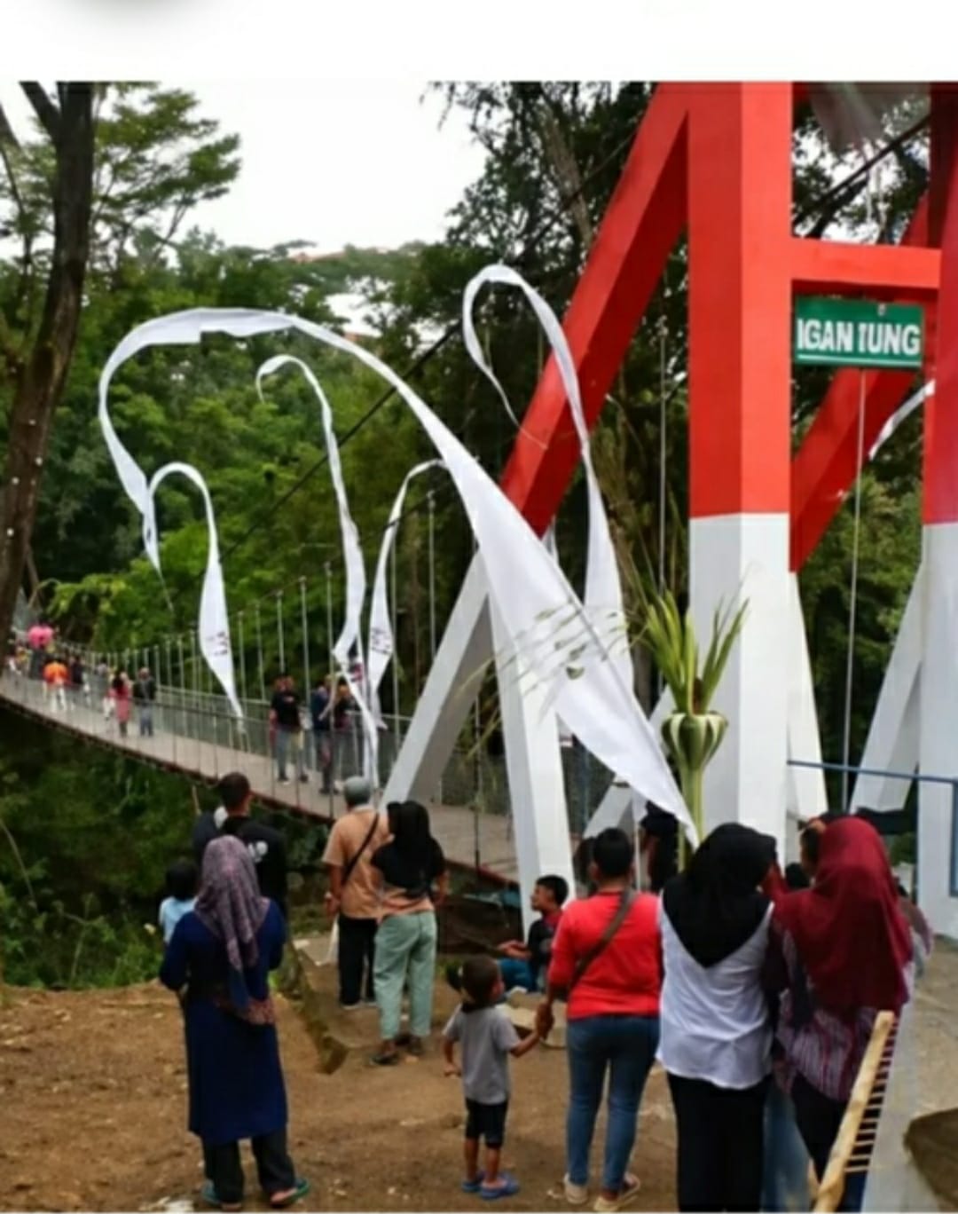 Caption: Jembatan Gantung Pongpet di Dusun Margajaya, Desa Margacinta, Kecamatan Cijulang, Kabupaten Pangandaran, tampak dipadati warga saat prosesi peresmian. Jembatan tersebut kemudian mengalami perubahan posisi dan kemiringan setelah banyak orang melintas secara bersamaan.