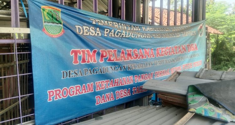 Caption: Spanduk program ketahanan pangan berupa budidaya burung puyuh dan jangkrik yang bersumber dari Dana Desa Tahap II Tahun Anggaran 2025 di Desa Pegadungan, Kecamatan Tempuran, Kabupaten Karawang. Kondisi program tersebut kini menjadi sorotan setelah aktivitas peternakan diduga berhenti. Caption: Spanduk program ketahanan pangan berupa budidaya burung puyuh dan jangkrik yang bersumber dari Dana Desa Tahap II Tahun Anggaran 2025 di Desa Pegadungan, Kecamatan Tempuran, Kabupaten Karawang. Kondisi program tersebut kini menjadi sorotan setelah aktivitas peternakan diduga berhenti.