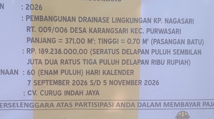 Caption: Papan informasi proyek pembangunan drainase lingkungan di Kampung Nagasari RT 009/RW 006, Desa Karangsari, Kecamatan Purwasari, Kabupaten Karawang. Proyek bersumber dari APBD Kabupaten Karawang Tahun Anggaran 2026 dengan nilai kontrak Rp189.238.000, panjang pekerjaan 371 meter dan tinggi 0,70 meter. Pelaksanaan dikerjakan CV. Curug Indah Jaya Diduga Proyek Drainase Karangsari Rp189 Juta Disorot, Pekerjaan Diduga Tak Sesuai Teknis