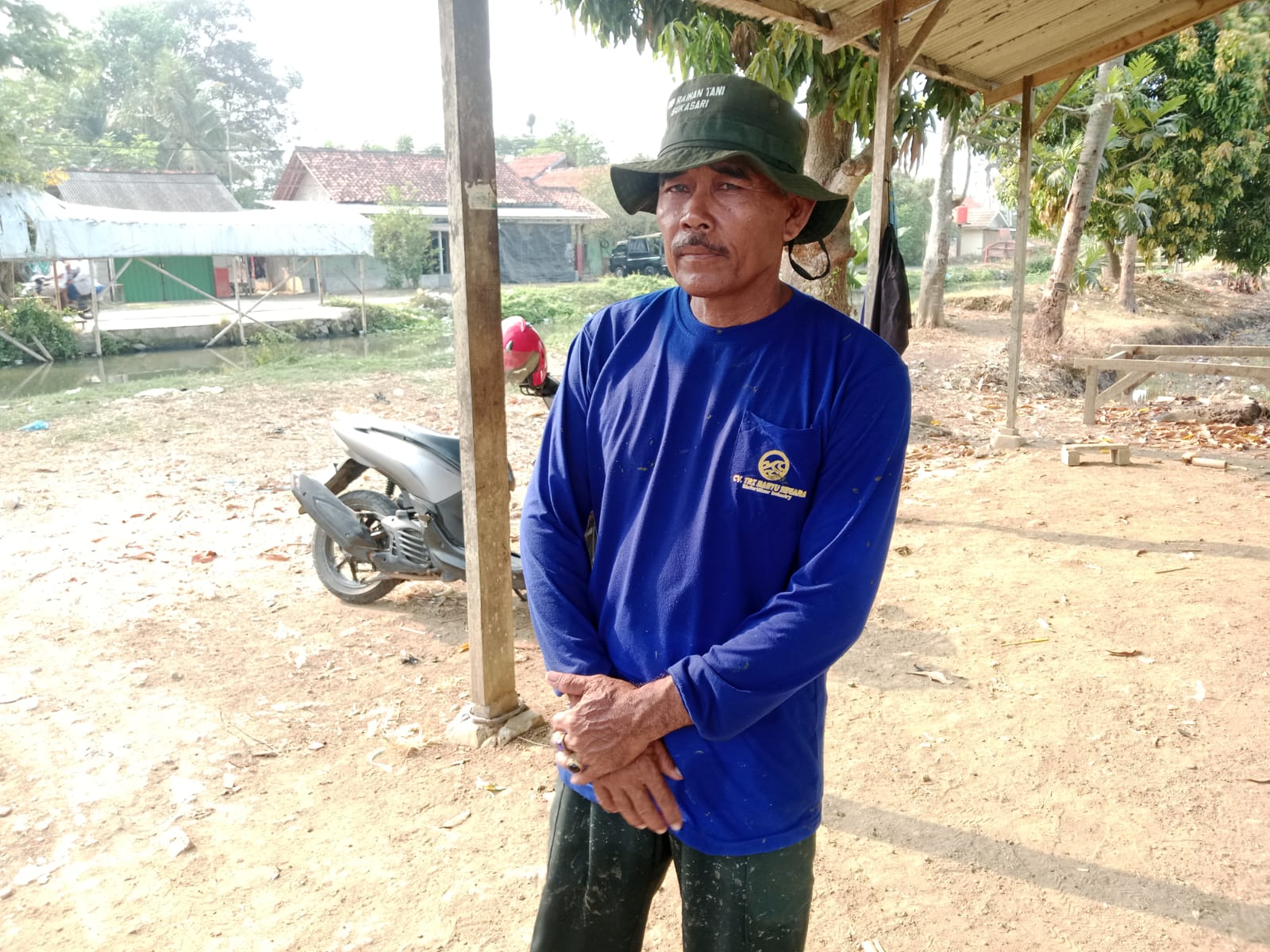 Caption: Ketua Gapoktan Desa Sukasari, Endang, saat berada di sekitar area persawahan yang terdampak kekeringan. Kondisi tersebut membuat sekitar 100 hektare lahan pertanian terancam gagal tanam dan petani berharap bantuan pompa air dari pemerintah.