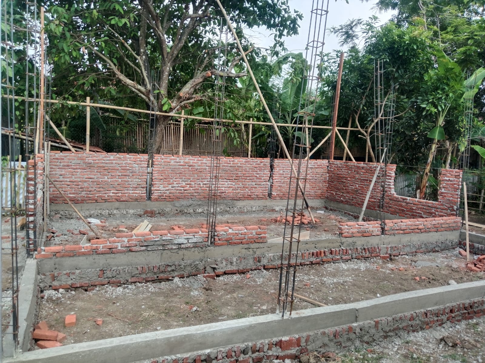Caption: Kondisi pembangunan gedung Majelis Taklim Baiturrohman di Dusun Babakan Kadaung RT 01/RW 07, Desa Jatimulya, Kecamatan Pedes, Kabupaten Karawang. Terlihat pekerjaan struktur fondasi, pasangan bata, serta rangka besi kolom yang masih dalam proses pengerjaan. Proyek tersebut menjadi sorotan setelah muncul dugaan ketidaksesuaian ukuran material besi dengan spesifikasi teknis yang dipersyaratkan. (Foto: Patriotjabar.com)