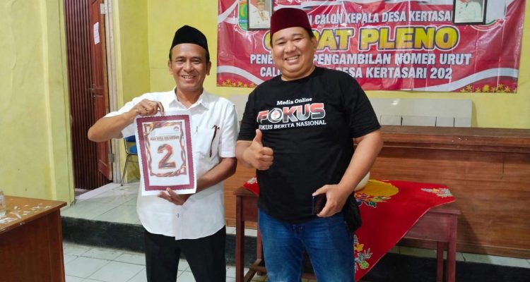 Caption: Kuwu Apud menunjukkan nomor urut 2 usai penetapan nomor urut calon Kepala Desa Kertasari, Kecamatan Rengasdengklok, Kabupaten Karawang, Kamis (15/10/2026). Dalam kesempatan tersebut, Kuwu Apud berfoto bersama salah satu tokoh pemuda sebagai bagian dari rangkaian tahapan Pilkades Kertasari. Caption: Kuwu Apud menunjukkan nomor urut 2 usai penetapan nomor urut calon Kepala Desa Kertasari, Kecamatan Rengasdengklok, Kabupaten Karawang, Kamis (15/10/2026). Dalam kesempatan tersebut, Kuwu Apud berfoto bersama salah satu tokoh pemuda sebagai bagian dari rangkaian tahapan Pilkades Kertasari.